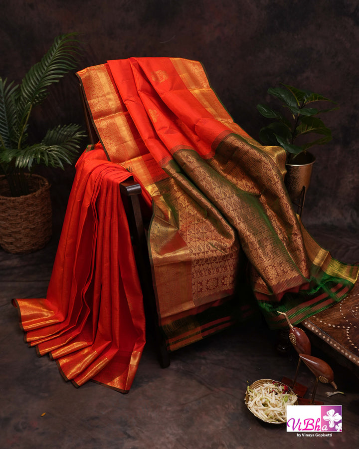 Vermilion Orange Kanchi Silk Saree with Gold Zari Weaving and Green Embroidered Blouse